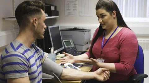 Getty Images Patient speaking with a primary care worker